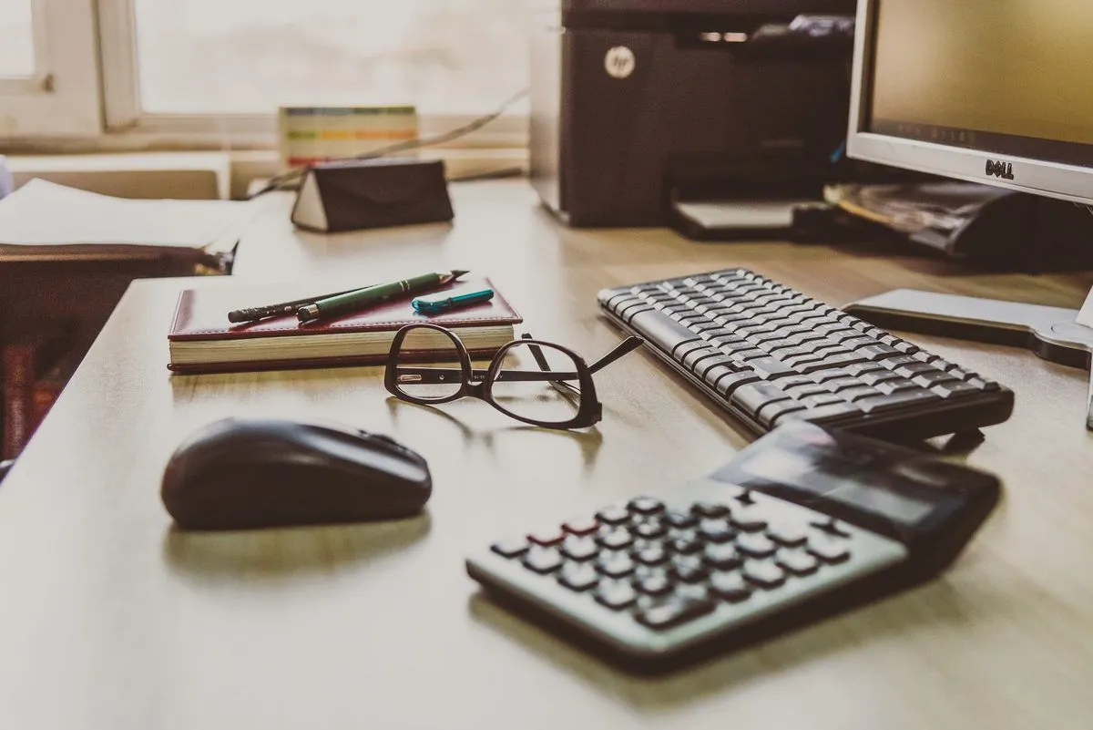 Accounting documents, a calculator and glasses on a desk